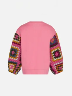 Maglia da bambina rosa con maniche all'uncinetto